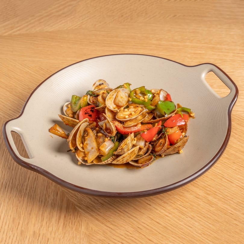 Stir-fried clams with red and green bell peppers, onions, and garlic in a savory sauce.